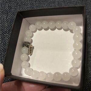 White Beaded Bracelet With Silver Charm.